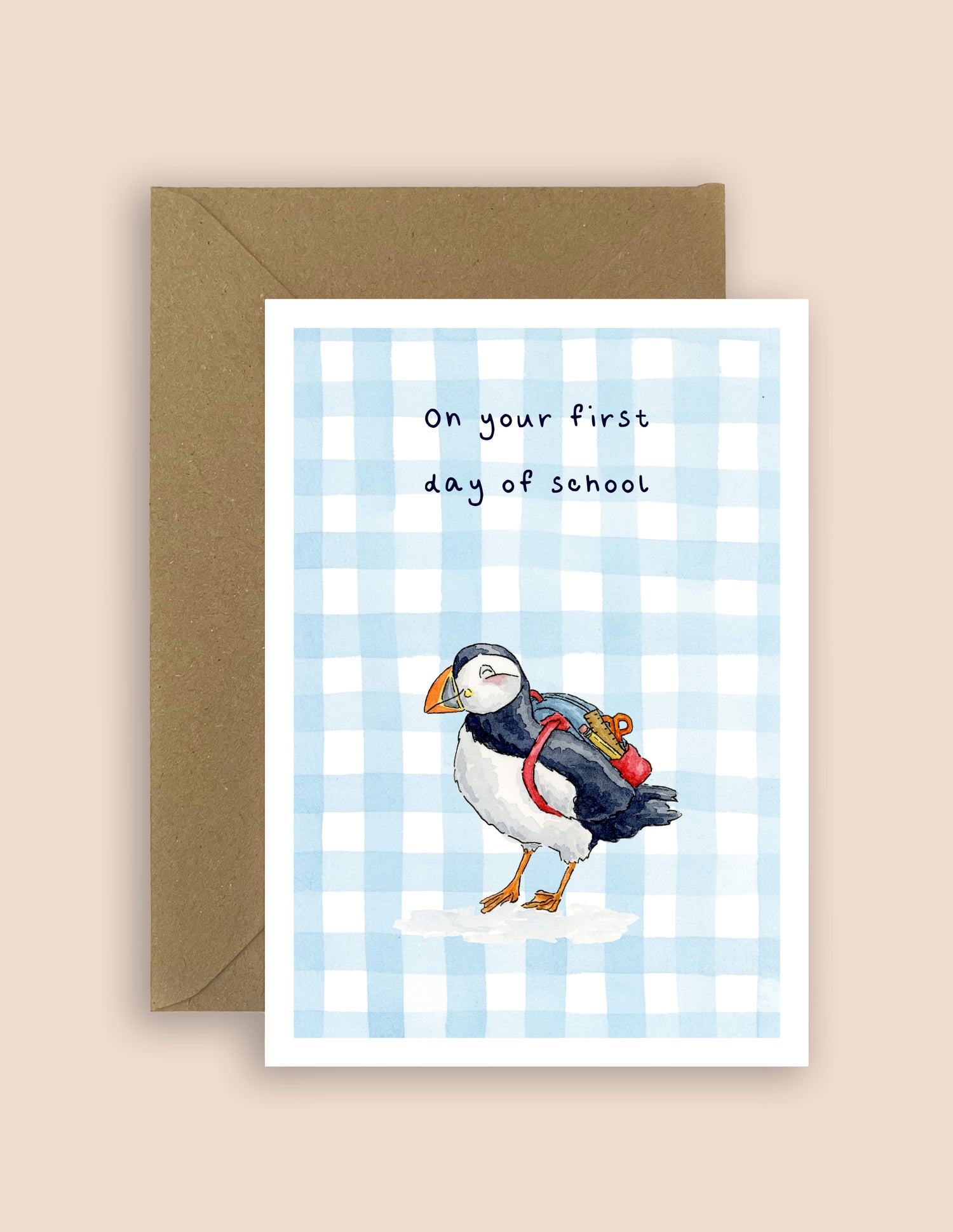 First day of school greeting card featuring an illustrated puffin with a backpack and kraft envelope